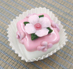 Pale Pink Primrose atop a Strawberry Petit Four Chocolate (81-102S)
